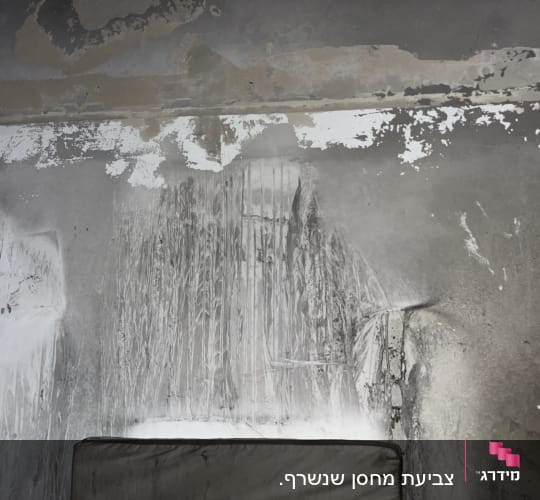 קיר עם סימני צבע מתקלף וכתמי צבע שונים